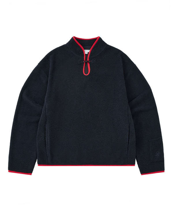 A cozy navy fleece pullover named the NAVY TEARDROP KNOT FLEECE by Sundae School, featuring a short zipper, red trim on the collar, cuffs, and hem, and long sleeves. This East Asian inspired garment is displayed laid flat on a white background.