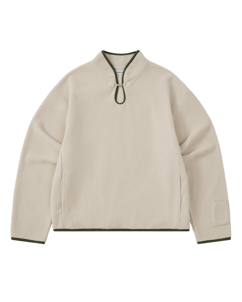 Introducing the TAUPE TEARDROP KNOT FLEECE from Sundae School: this cozy fleece pullover features long sleeves and a rounded collar with a front loop closure. Dark green trim accents the collar, cuffs, and hem, while its minimalistic design is elevated by subtle East Asian-inspired details for a timeless aesthetic.