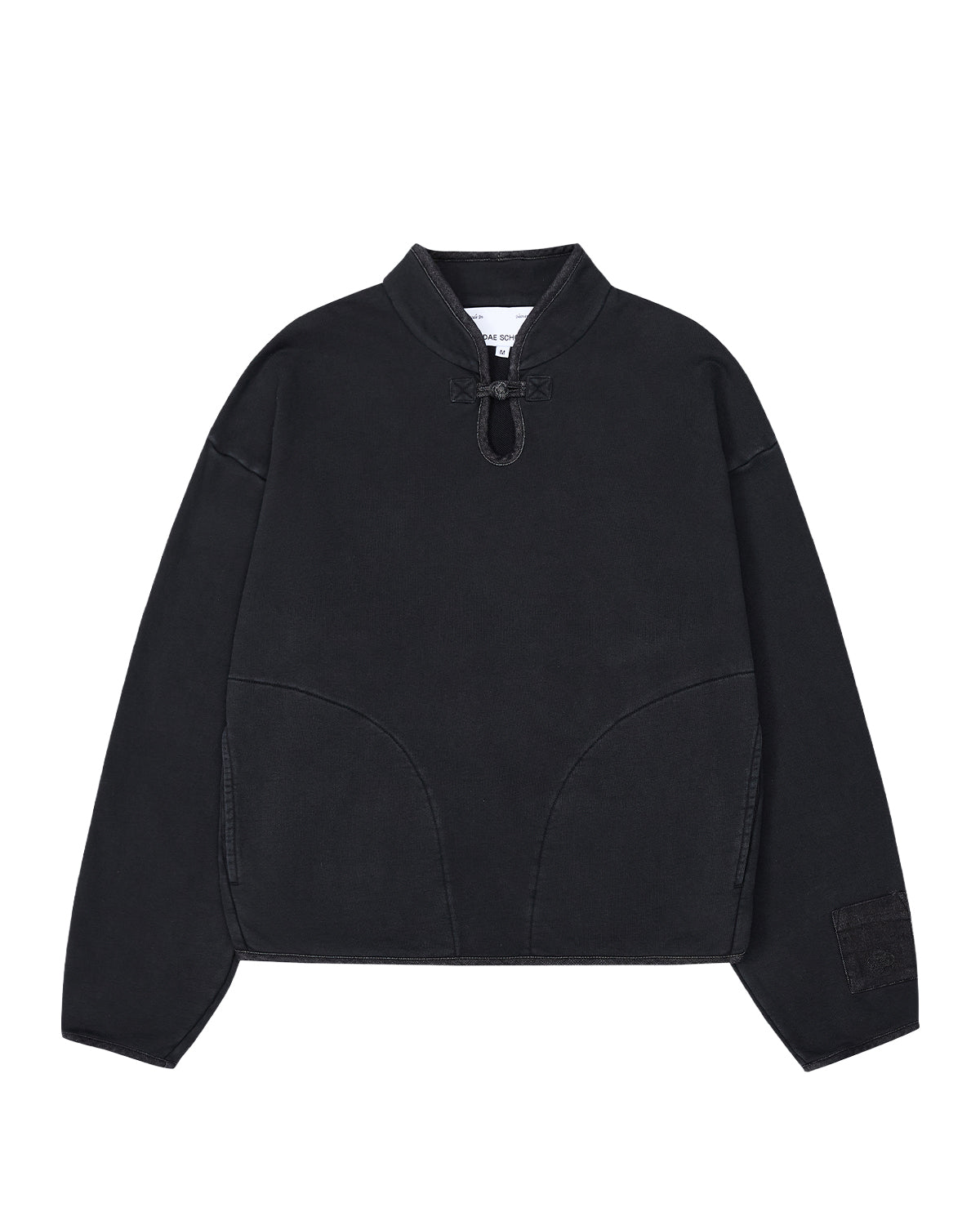Introducing the BLACK TEARDROP KNOT SWEATSHIRT from Sundae School—a minimalist, loose-fitting pullover crafted from 100% cotton. This black sweatshirt features long sleeves, a high collar with a front drawstring tie, curved seam details on the front, and a small patch adorning the left sleeve.