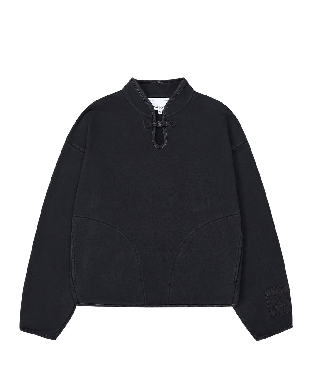 Introducing the BLACK TEARDROP KNOT SWEATSHIRT from Sundae School—a minimalist, loose-fitting pullover crafted from 100% cotton. This black sweatshirt features long sleeves, a high collar with a front drawstring tie, curved seam details on the front, and a small patch adorning the left sleeve.