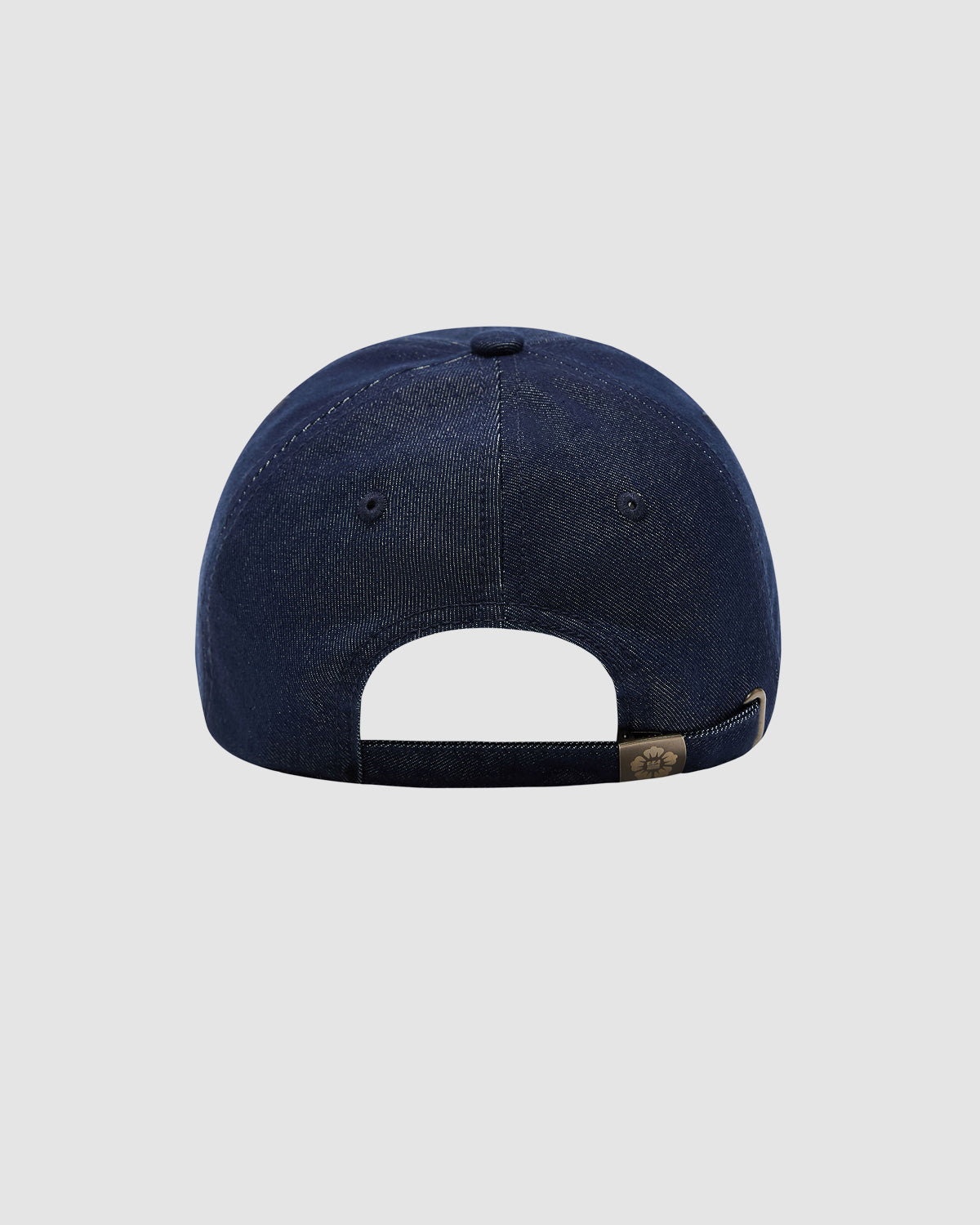 The INDIGO DENIM TIGER CAP by Sundae School is a navy blue six-panel cap with an adjustable denim strapback, metal buckle, and an open section above the strap. Shown from the back against a light gray background.