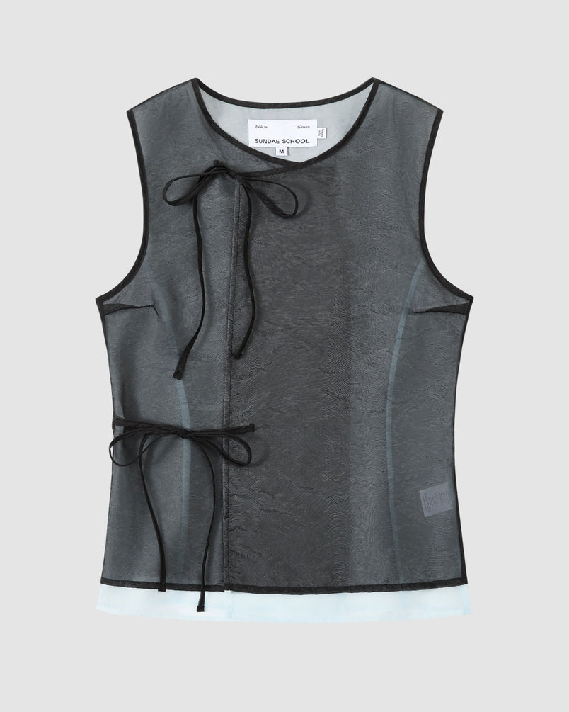 The BLACK VITA ORGANZA VEST by Sundae School is a sleeveless sheer black mesh top with black trim and Korean goreum ties at neck and side. A white label is visible at the neck. Displayed on a plain light gray background.