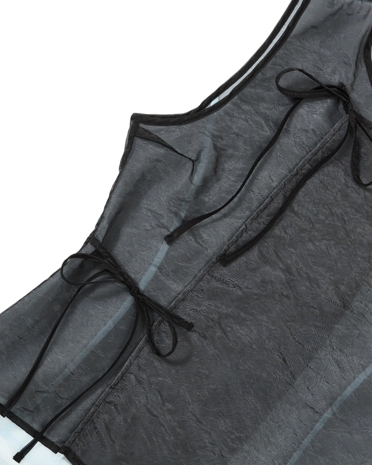 Close-up of the VITA ORGANZA VEST by Sundae School in sheer black layered over blue, featuring Korean goreum tie closures at the side with elegant black ribbons, displayed against a white background.