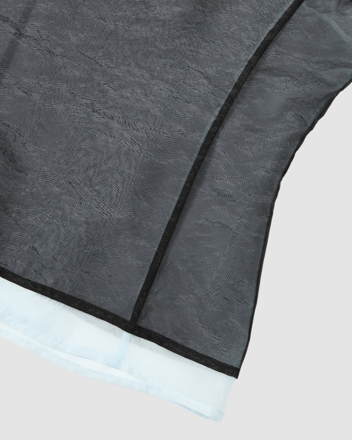 Close-up of the Sundae School BLACK VITA ORGANZA VEST: a sheer black double-layered vest with wavy texture, black seam lines, and a white lining, shown against a plain light gray background.