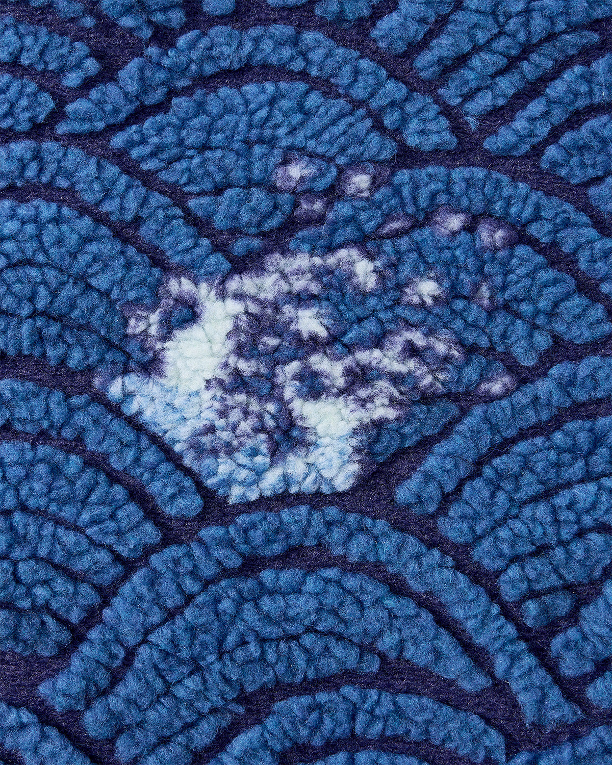 Close-up of Sundae School's BLUE WAVE FLEECE: blue textured fabric with raised Korean ocean-inspired semi-circles, deep blue lines, and a white spot—perfect for custom wave motif jacquard or embossed pile fleece jackets.