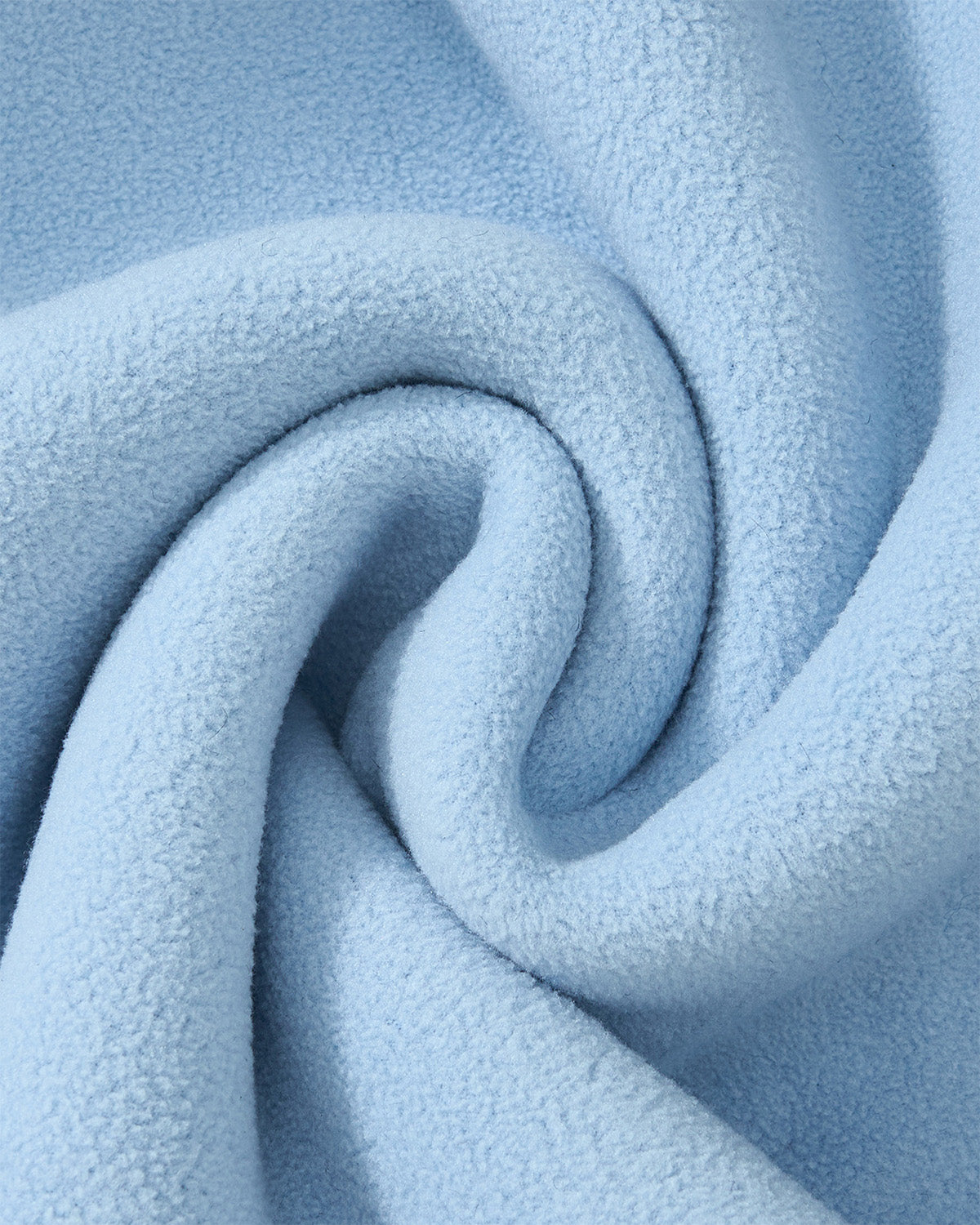 Close-up of Sundae School's BLUE WAVE FLEECE fabric in light blue, showcasing its soft, embossed pile and plush, textured surface, arranged in a gentle swirl.