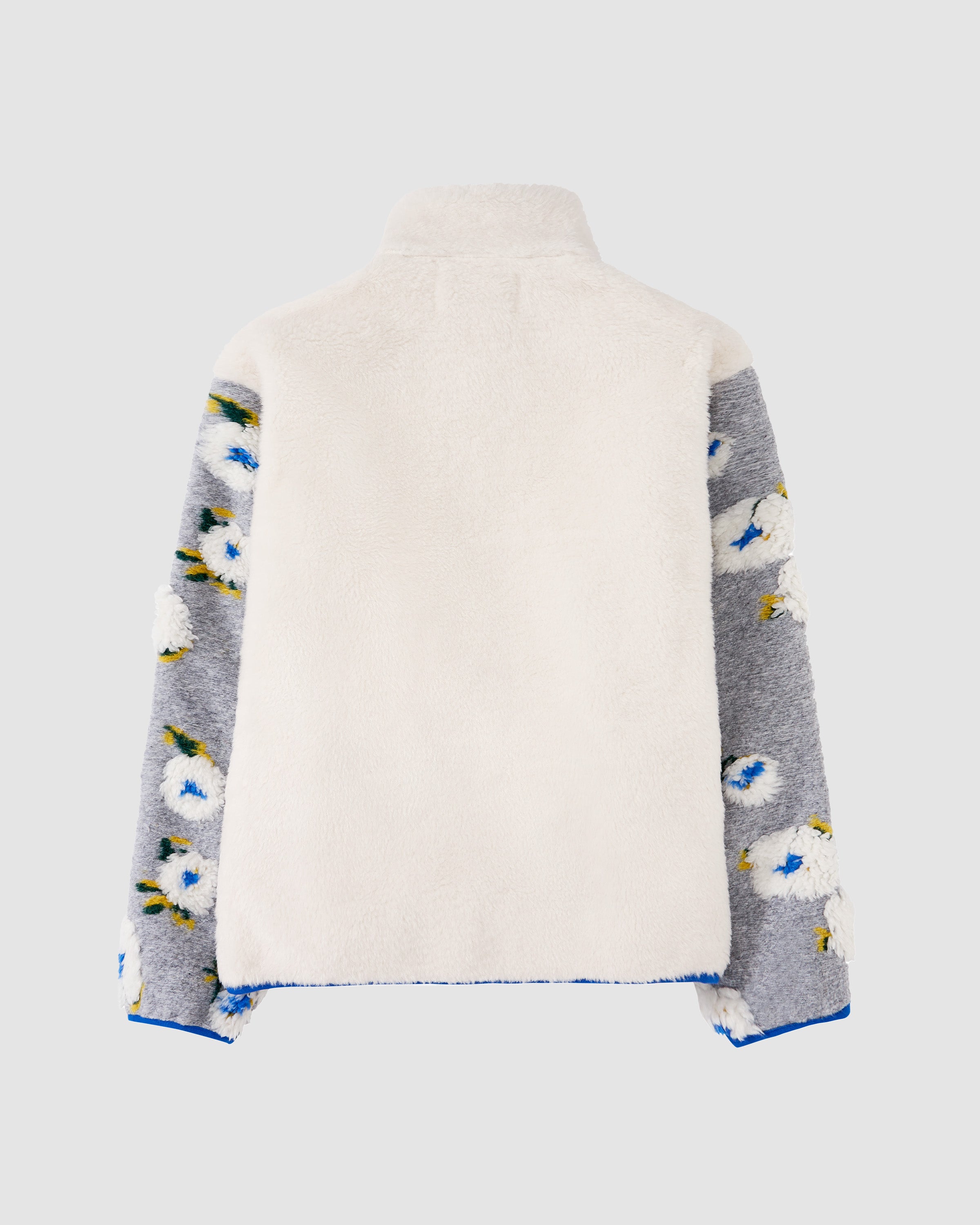 The IVORY MUGUNGHWA FLEECE by Sundae School is a jacquard jacket with a solid white back, high collar, and grey sleeves adorned with white and blue hibiscus, displayed on a plain light background.