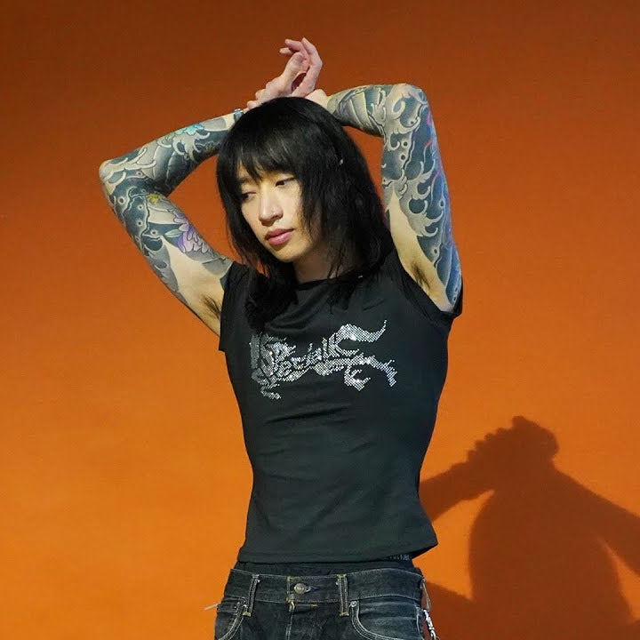 KESHI wearing the Special K Diamante tee against an orange background