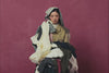 A slow motion of a pile of fabric being thrown on to a woman wearing SUNDAE SCHOOL ASYMMETRIC WORK JACKET