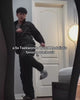 A video showcasing a black Korean-inspired track suit from Sundae School modeled by a Taekwondo athlete. He demonstrates the outfit's mobility with high martial arts kicks before showing off key design features, including a Hanbok-style asymmetric chest tie, a double zipper with custom hardware, sleeve stash pockets, wide-leg fold pants, an elastic drawstring waistband, and signature adjustable cord toggles.